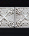 photo of white plaster casts of an architectural ornament with geometric lines and leaf patterns in a row against black background