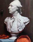 Photo of Cast Painting of Plaster Cast of Lafayette on a blue table with a red cloth and dark wooden background
