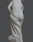 photo of plaster cast of sculpture of partially nude female, namely Venus, leaning forward to wash her left leg with a gray background