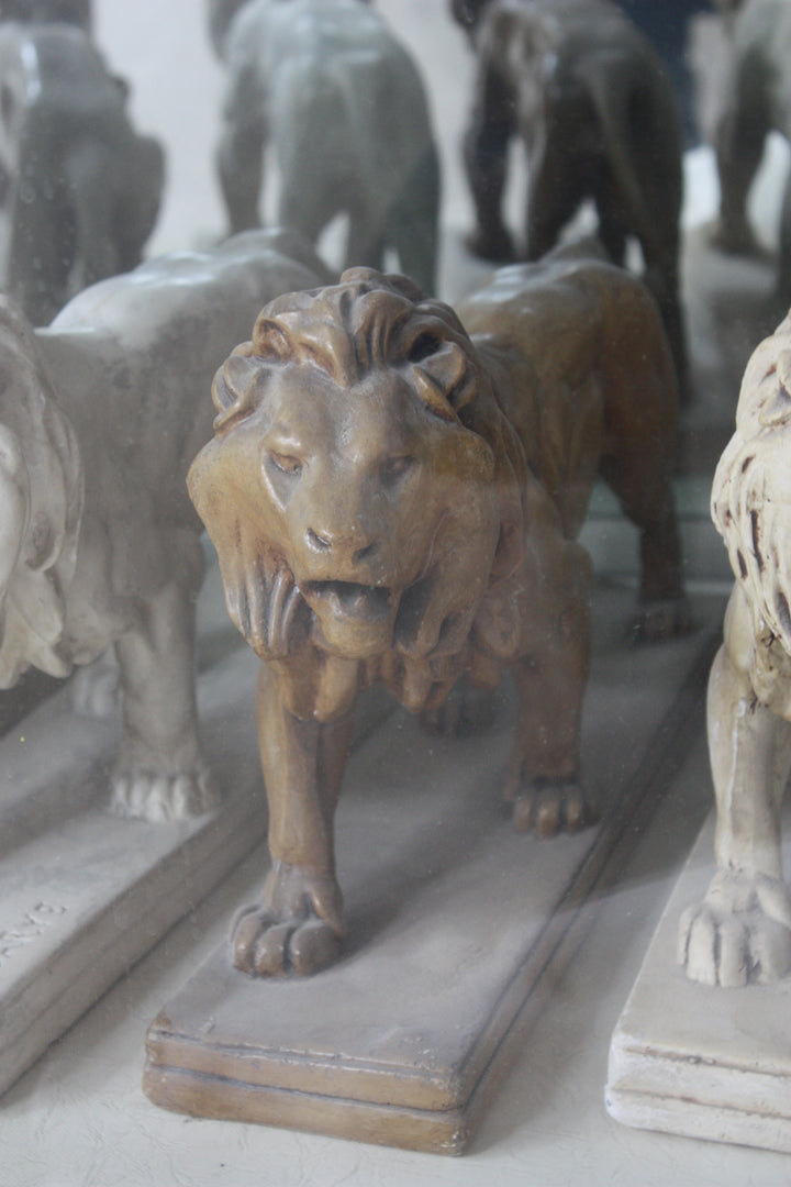 Photo of plaster casts of lions in two rows, cropped.