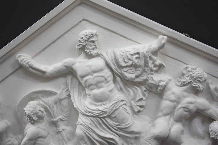 closeup photo of white triangular plaster cast sculpture relief of the god Zeus in the center and the Giants around him on a gray background