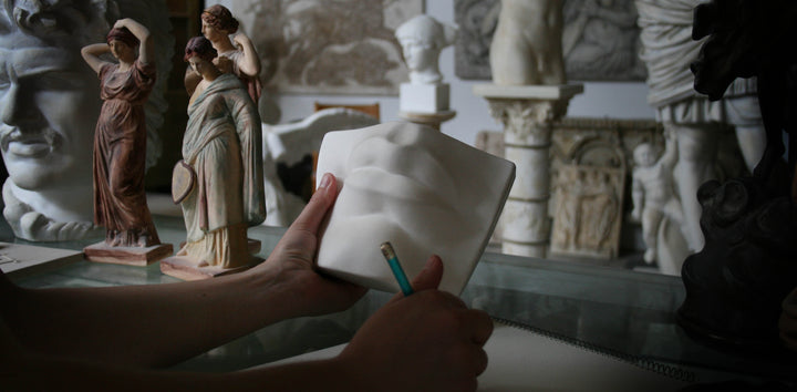 Photo of someone's hands holding a pencil and holding Michelangelo's David mouth cast in the gallery
