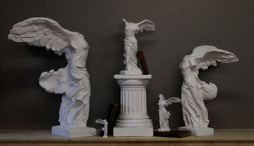 five sculpture reproductions of the Victory of Samothrace set on a surface with a small Greek-like column pedestal under one and an assortment of antique books