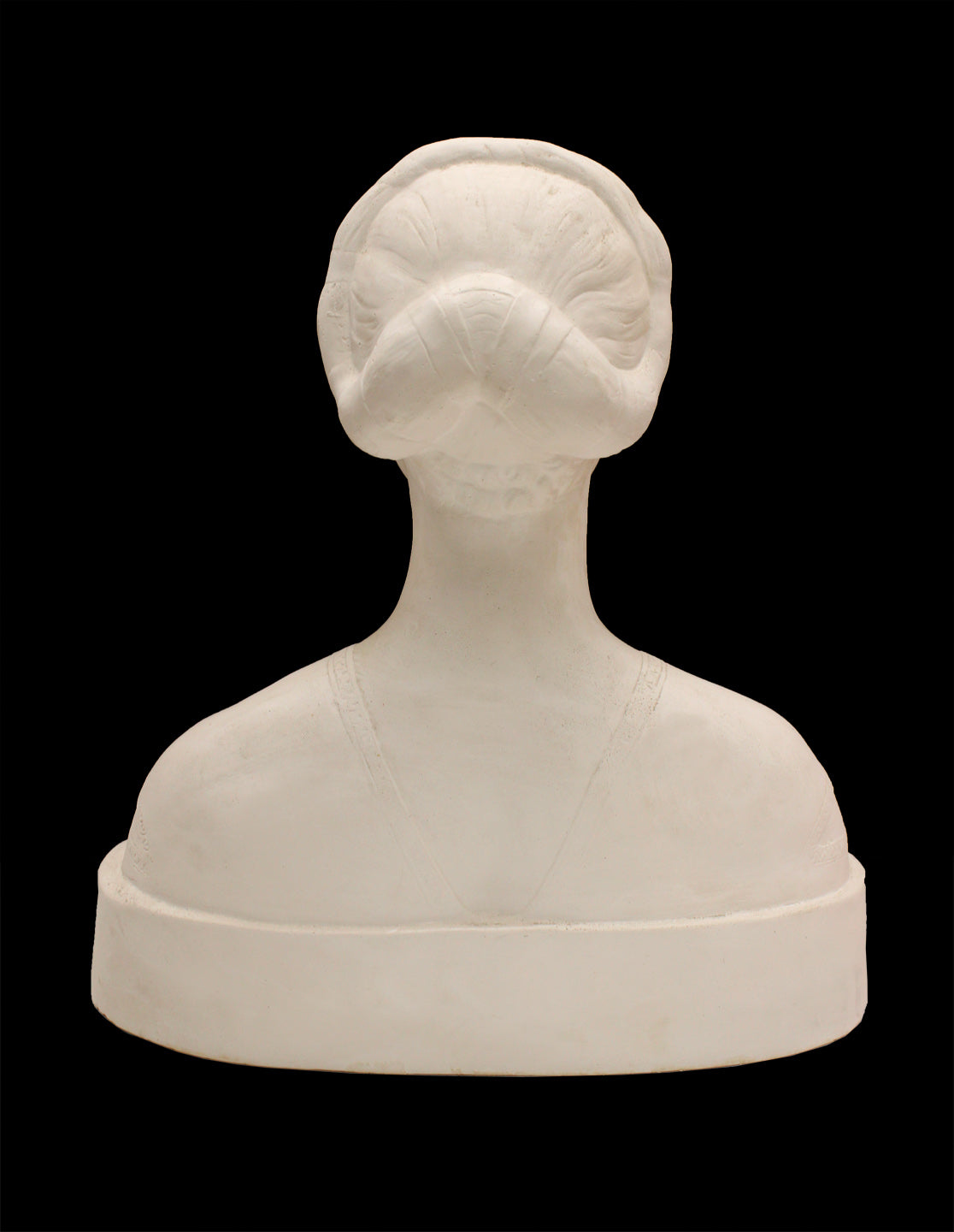 back view photo of white plaster cast sculpture of female bust cropped at shoulders with decorative base against black background