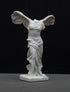 photo of white plaster cast sculpture of winged, headless female figure with flowing drapery on a gray background