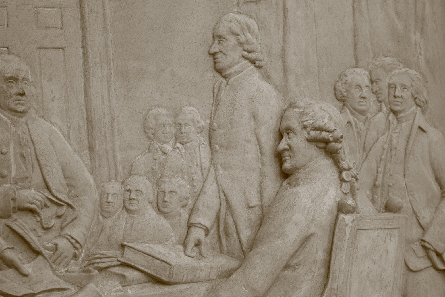 detail photo of off-white plaster cast relief sculpture of men around a table aka signing the Declaration of Independence