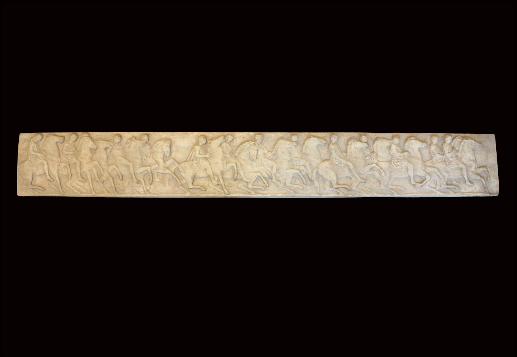 photo of plaster cast relief sculpture of horseback riders in a row - from the Parthenon - on black background