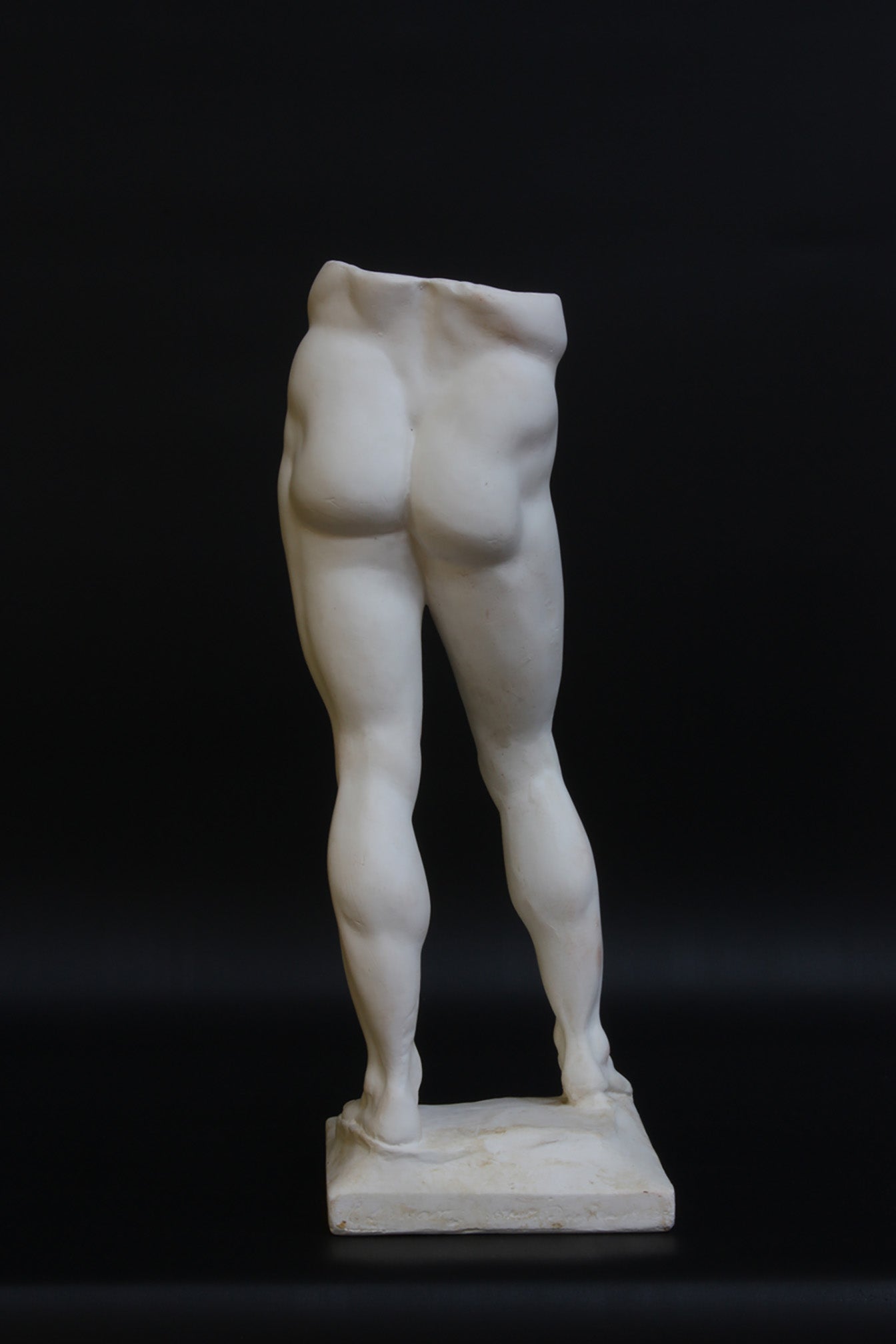 Photo of a decorative sculpture of a man's torso on a black background