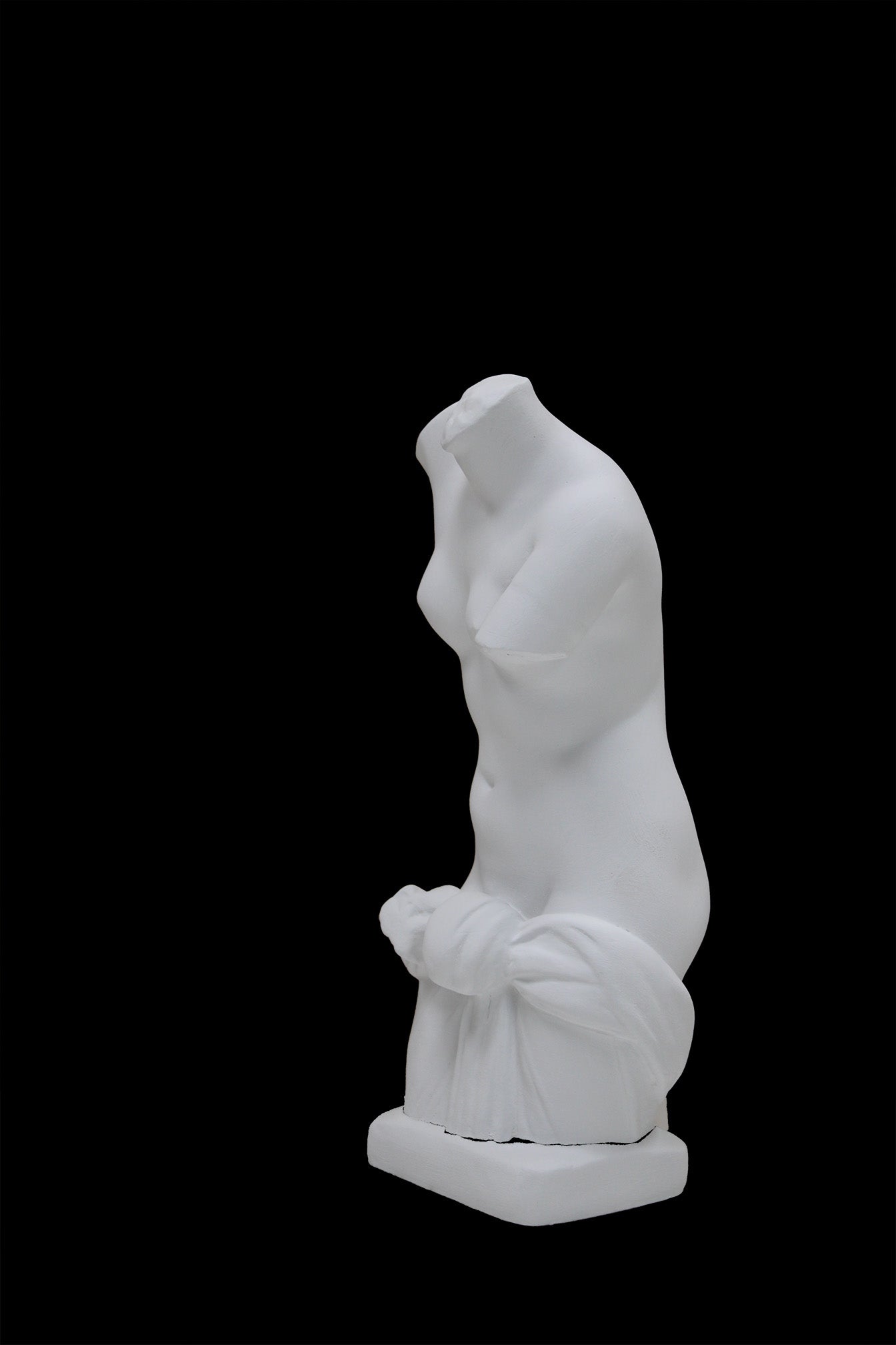 Photo of a sculpture of a ladies torso on a black background 