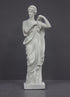 photo of white plaster cast statue of female in robes with left arm raised and holding robe on gray background