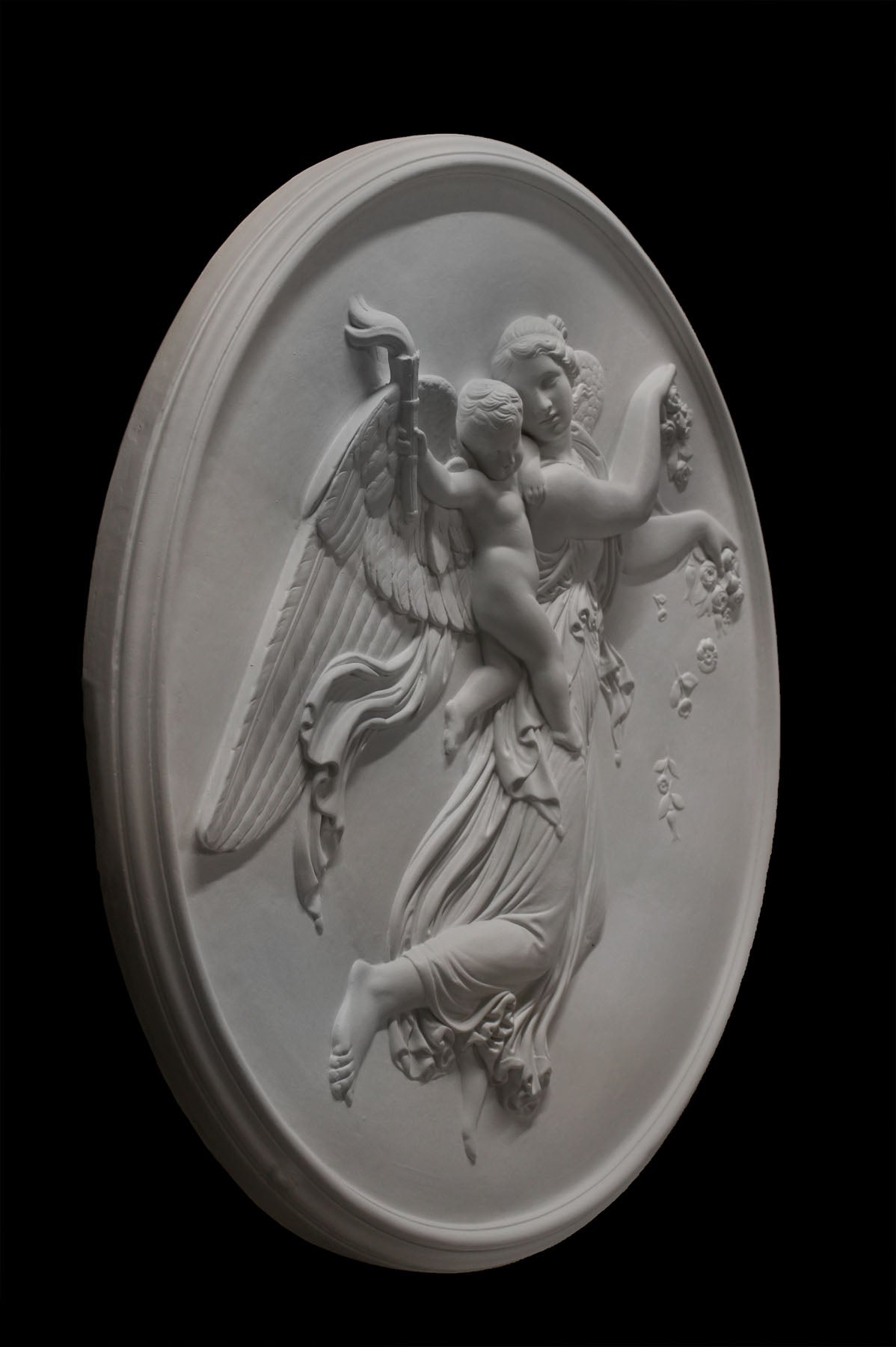  photo of plaster cast relief of female with wings flying and a cherub on her back on black background