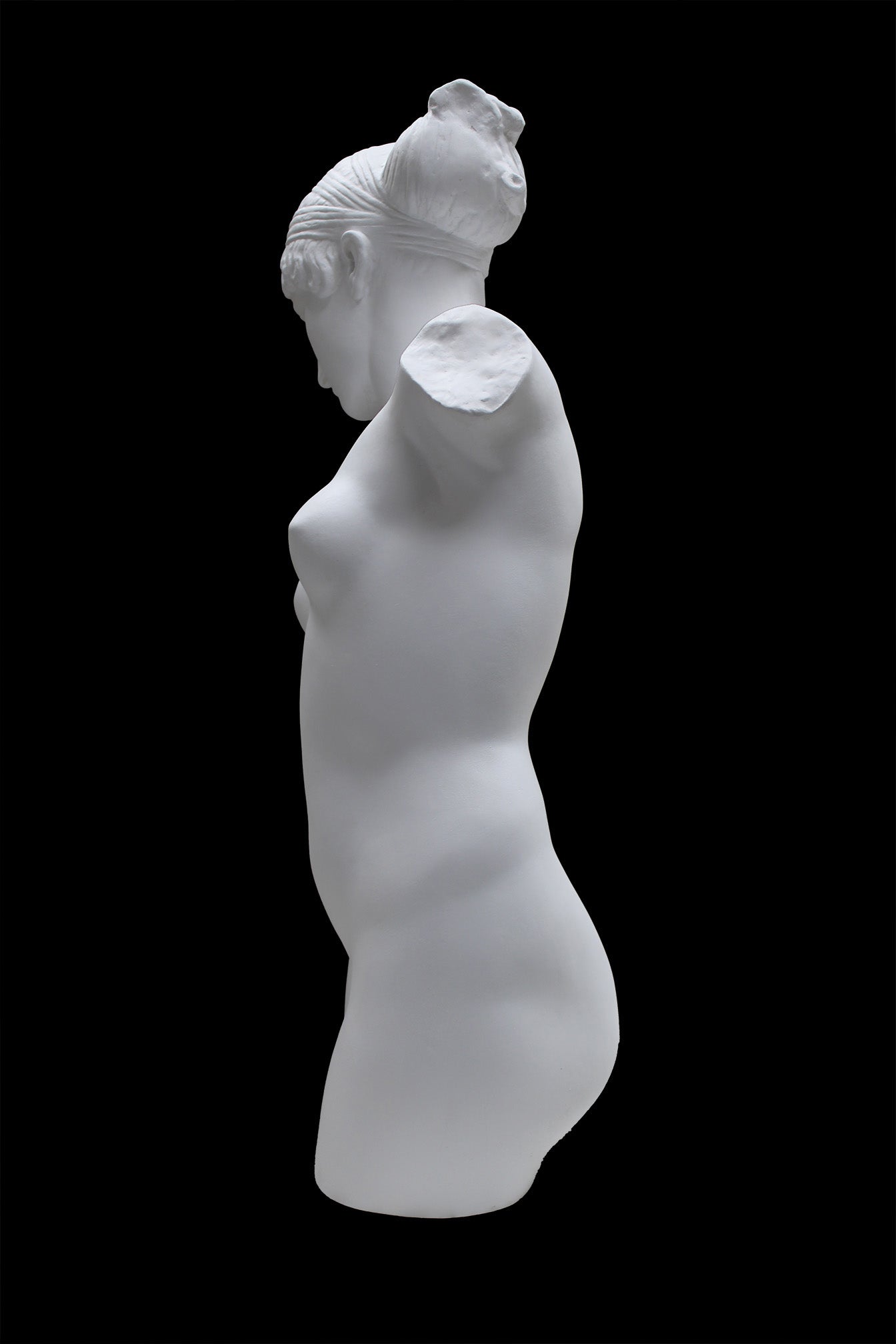 Photo of a sculpture of a female torso with a head