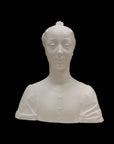 photo of white plaster cast of female bust with up-do and dress against black background