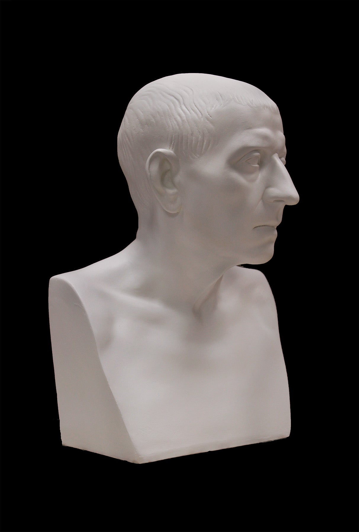 image of a plaster statue of a bust of cicero on a black background