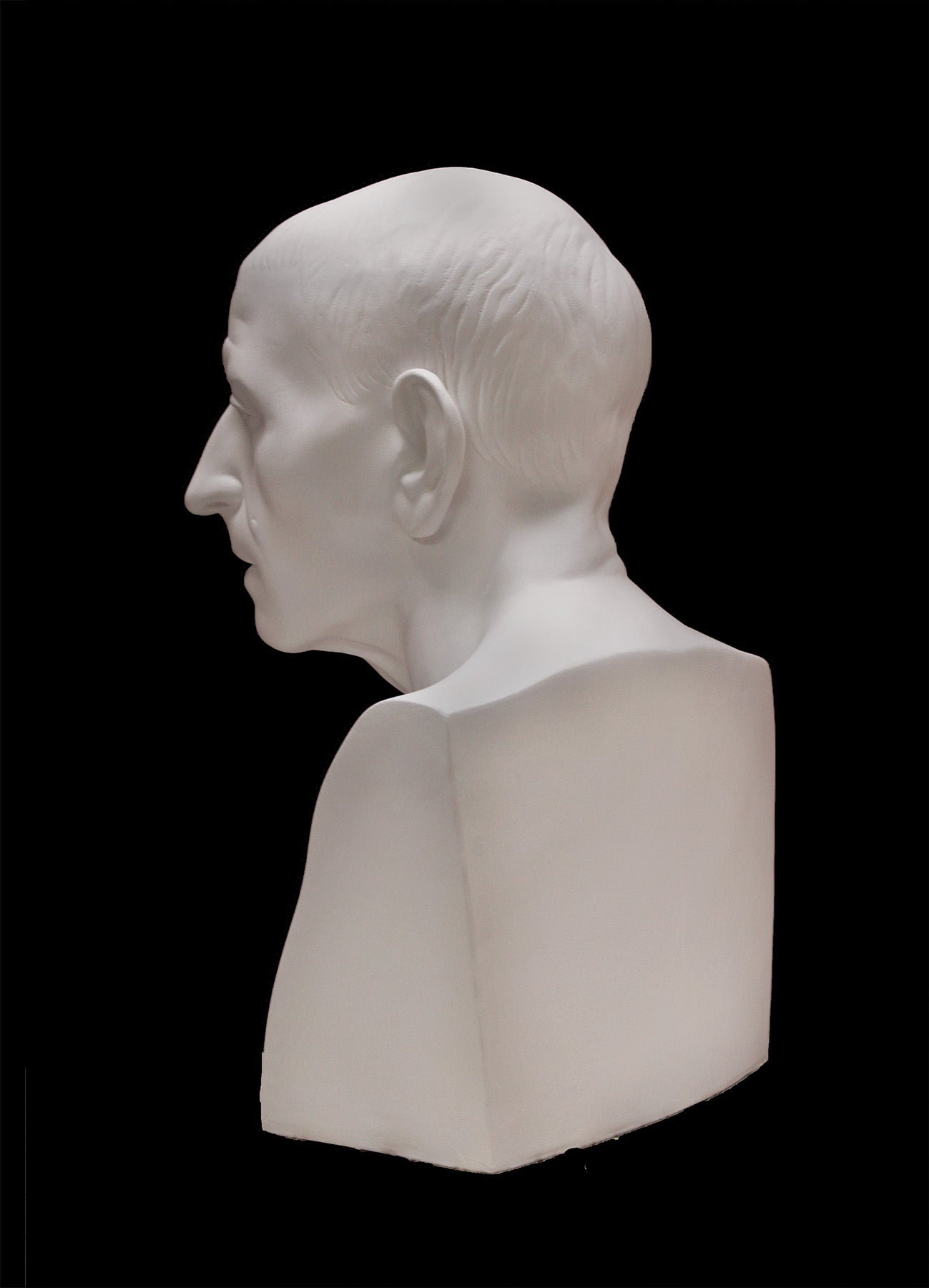 image of a plaster statue of a bust of cicero on a black background