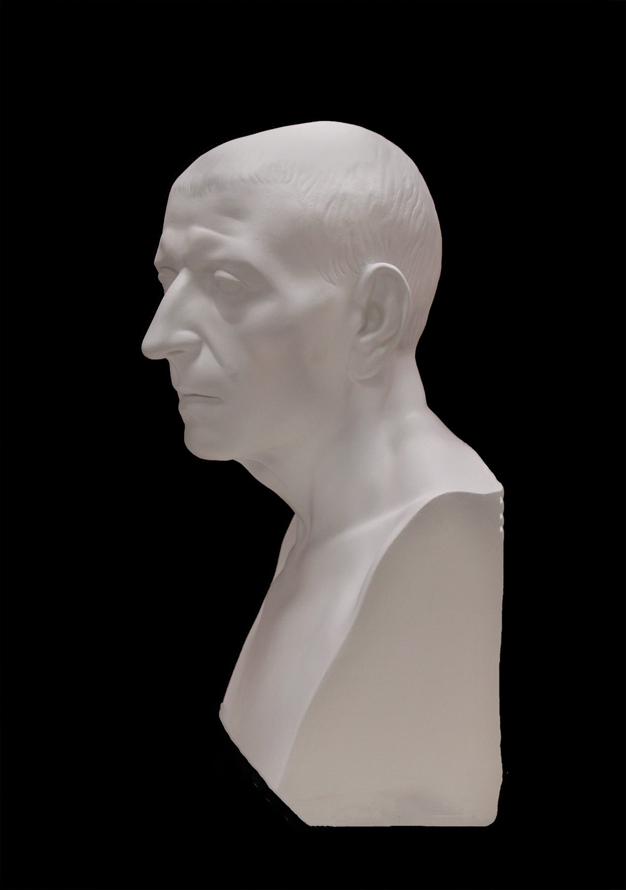 image of a plaster statue of a bust of cicero on a black background