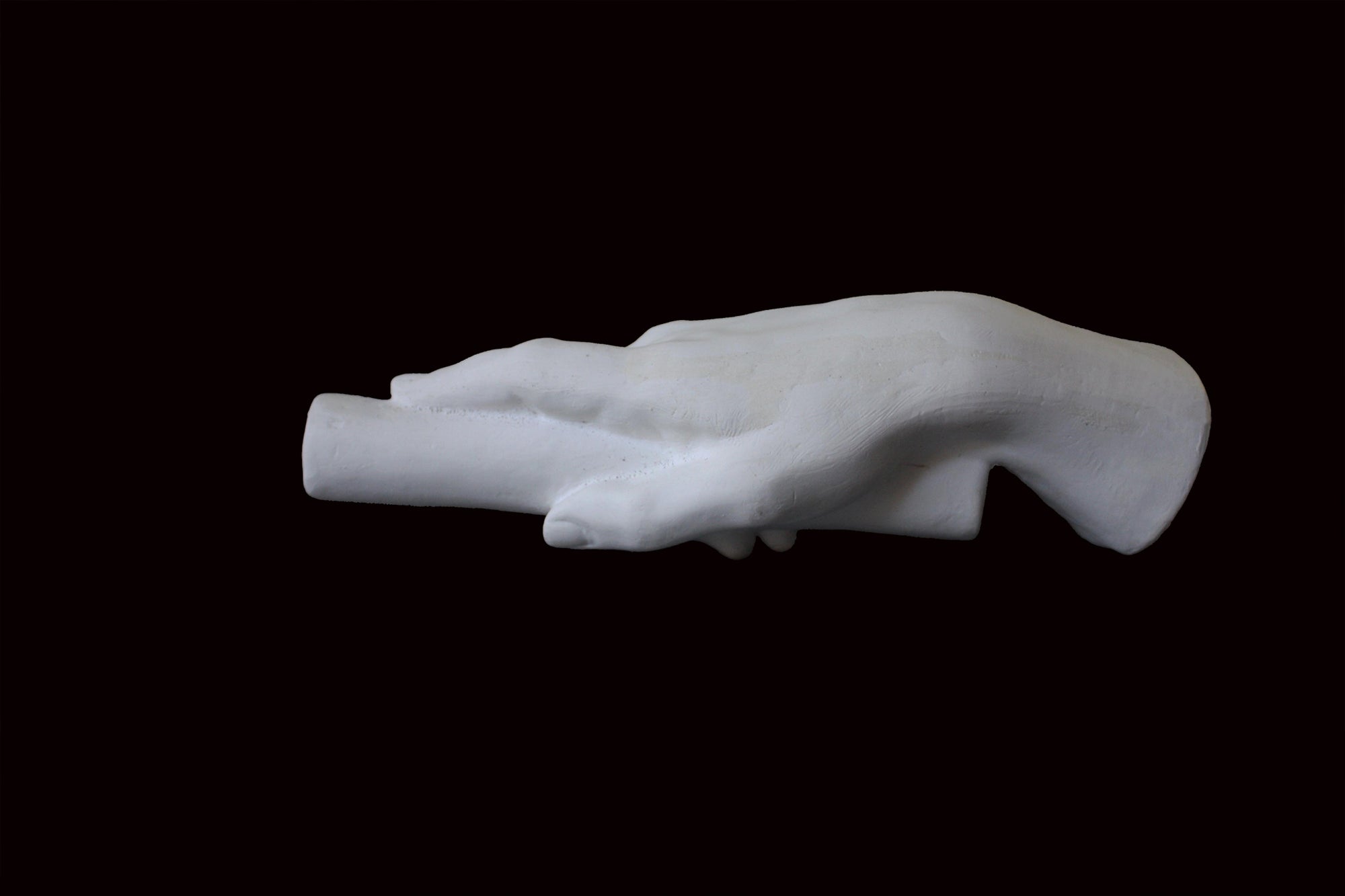 photo of white plaster cast of right hand grasping a staff or pole against black background