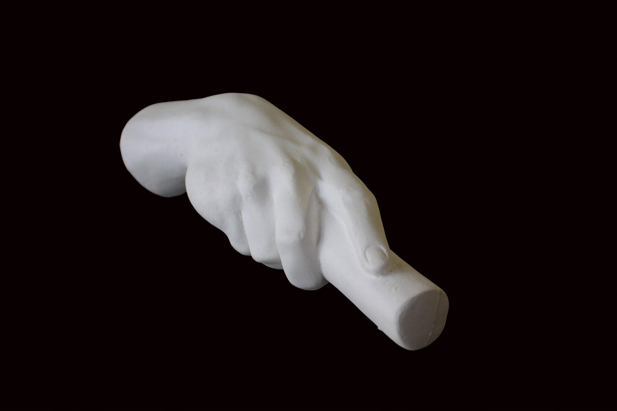 photo of white plaster cast of right hand grasping a staff or pole against black background