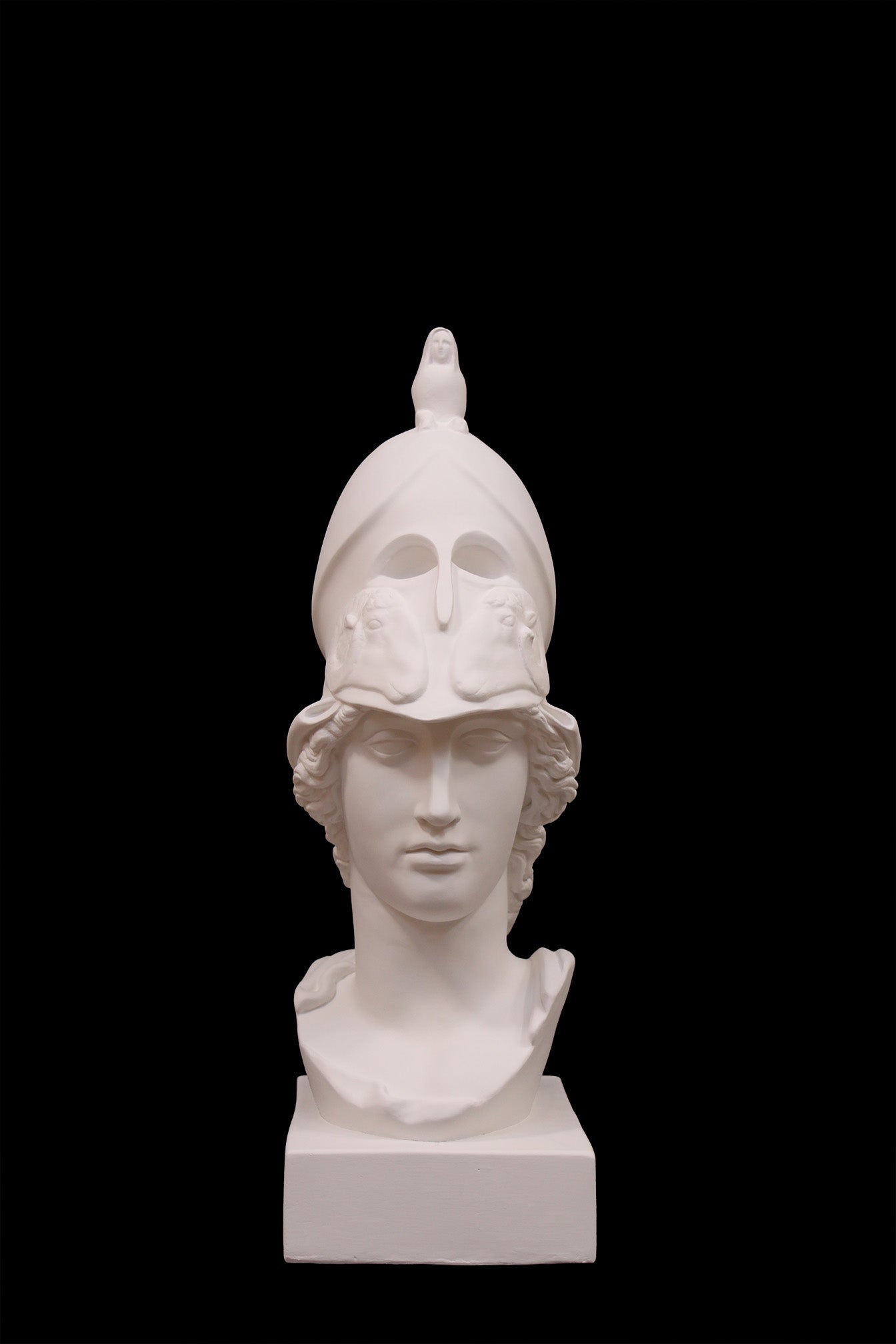 photo of plaster cast sculpture bust of female head, namely the goddess Athena, with a helmet on a black background