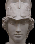 photo of plaster cast sculpture bust of female head, namely the goddess Athena, with a helmet on a black background