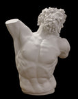 photo with black background of plaster cast of sculpted male torso and head with curly hair and beard, namely Laocoon