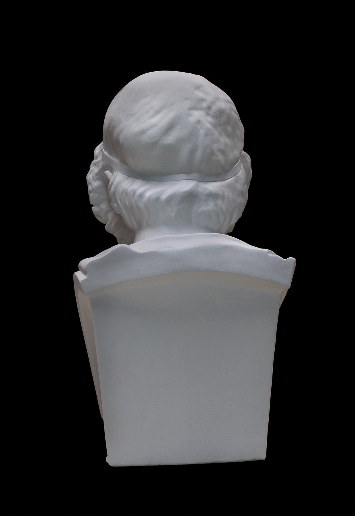 image of a plaster statue of a bust of homer on a black background