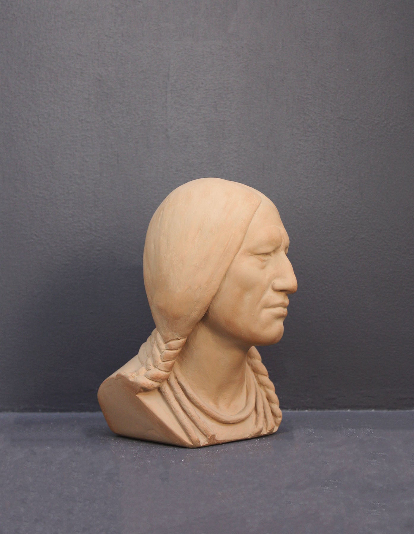 image of a terracotta-colored plaster bust of the well-known Native American Massasoit on a gray background