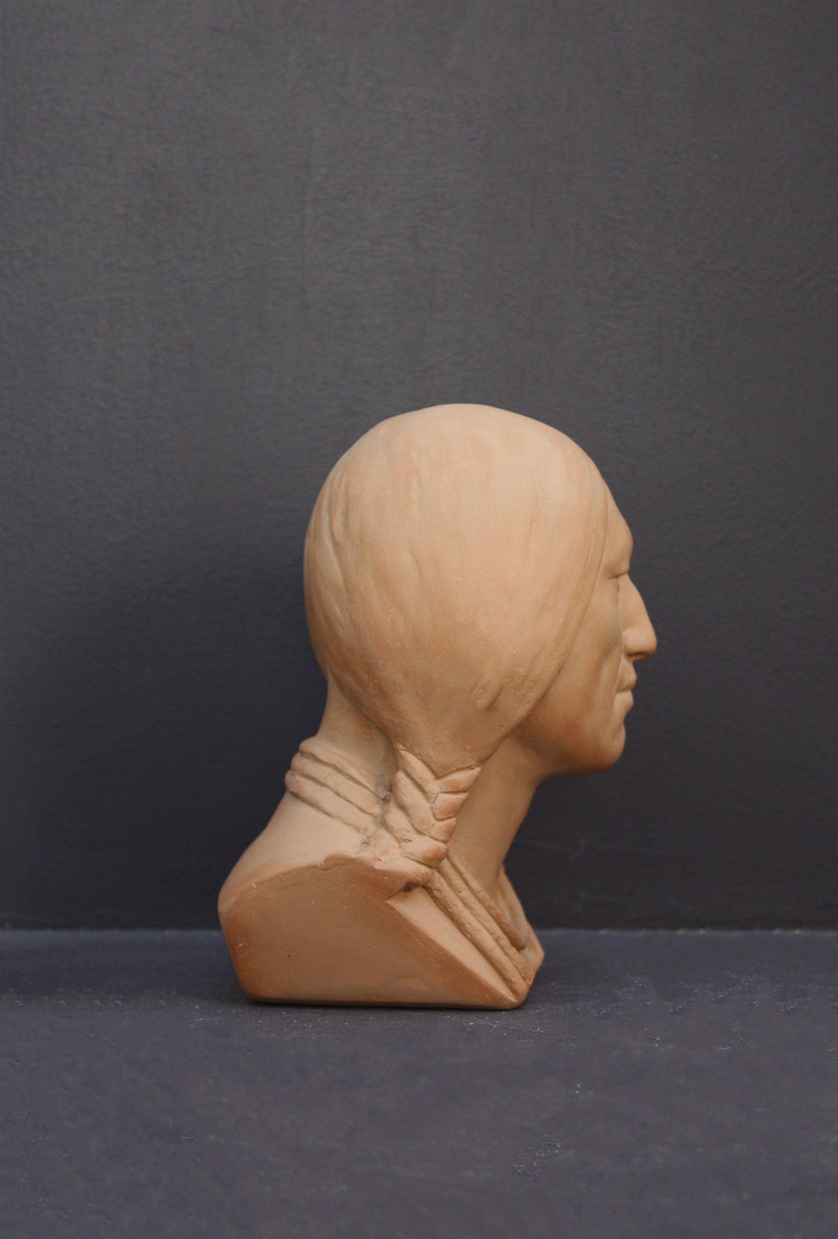 image of a terracotta-colored plaster bust of the well-known Native American Massasoit on a gray background