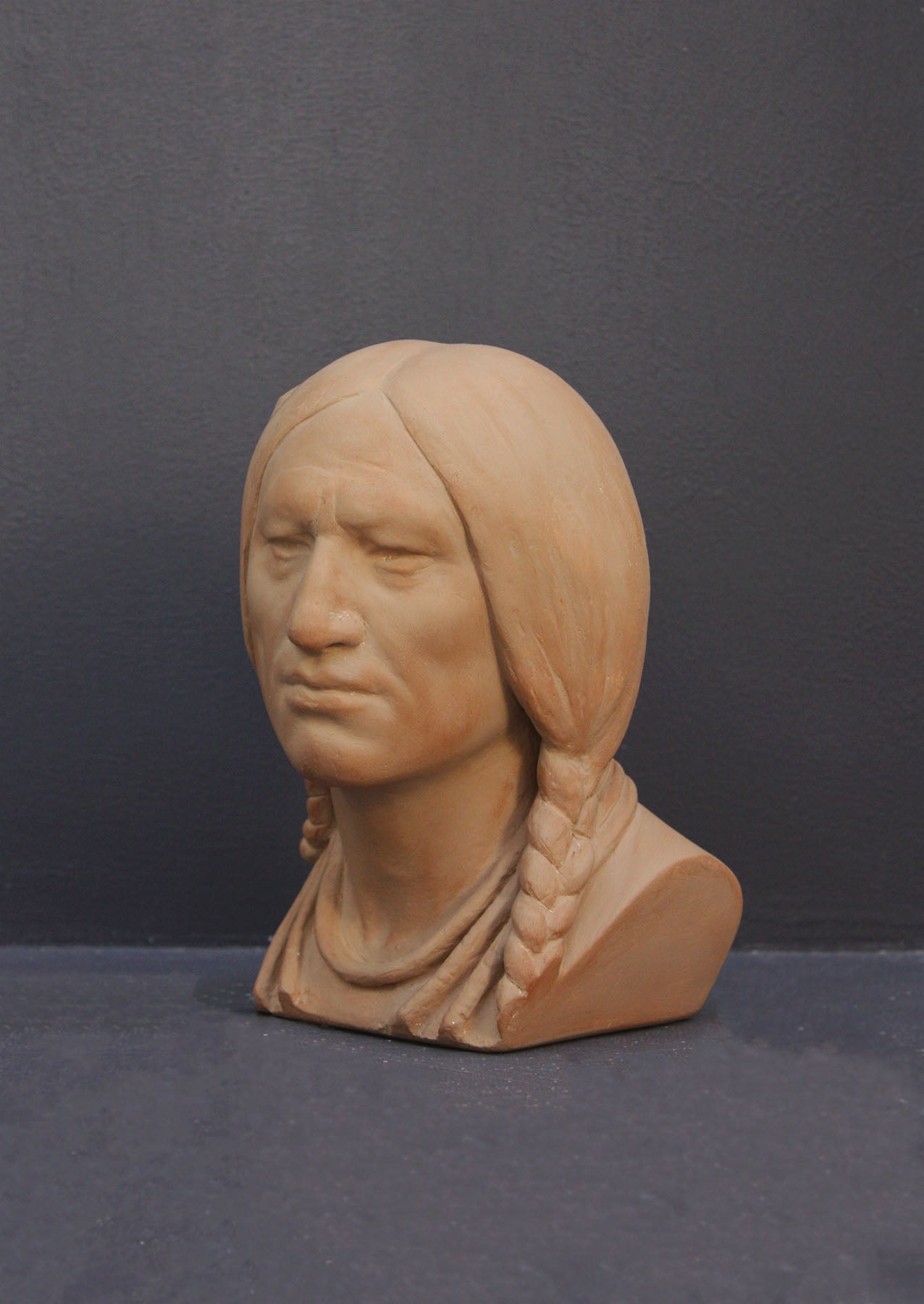 image of a terracotta-colored plaster bust of the well-known Native American Massasoit on a gray background