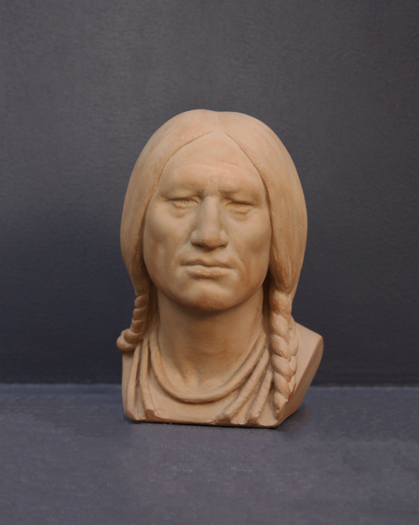 image of a terracotta-colored plaster bust of the well-known Native American Massasoit on a gray background