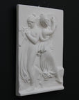 Photo with black background of plaster cast sculpture relief of females playing instruments