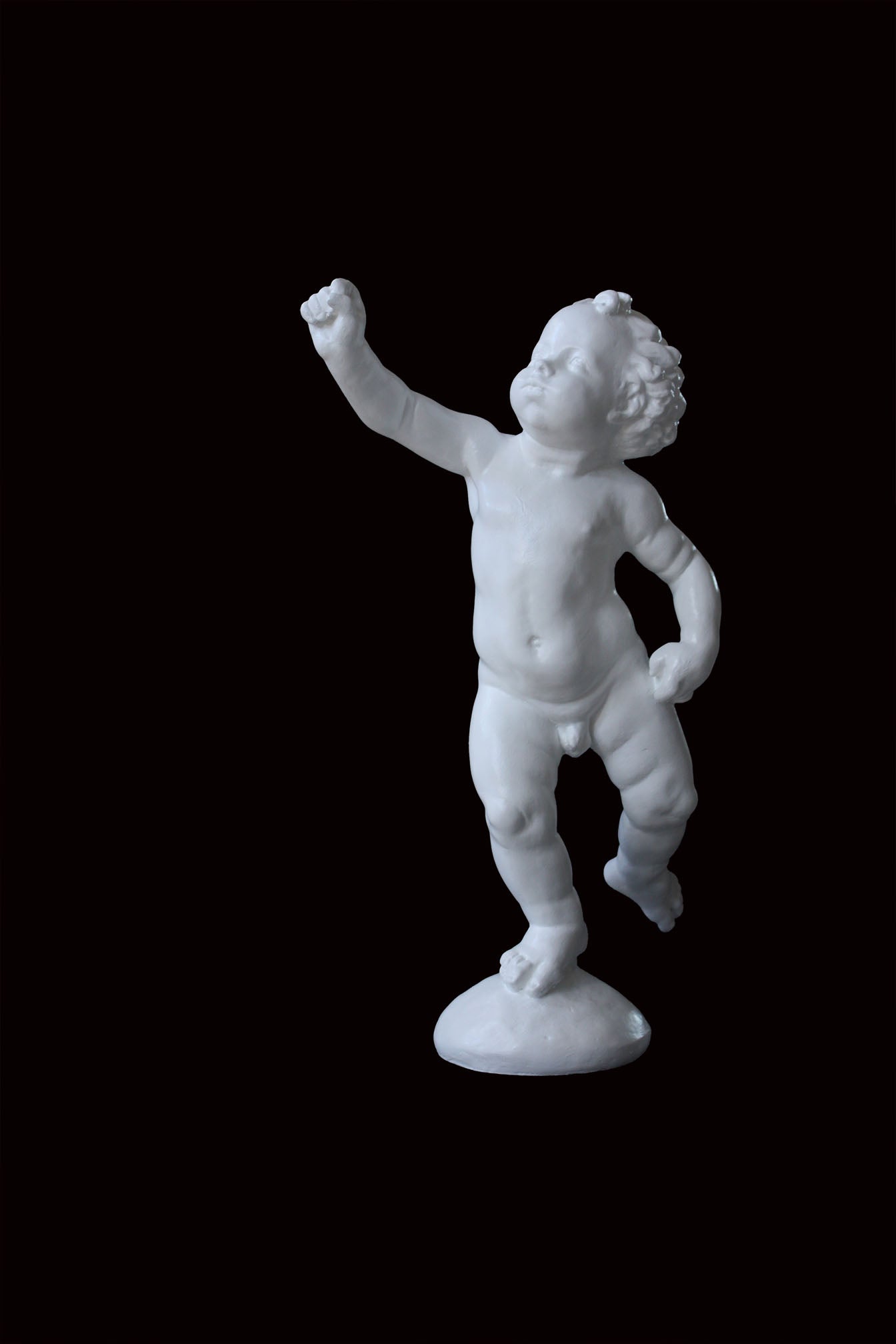 Photo of a sculpture of a cherub on a black background