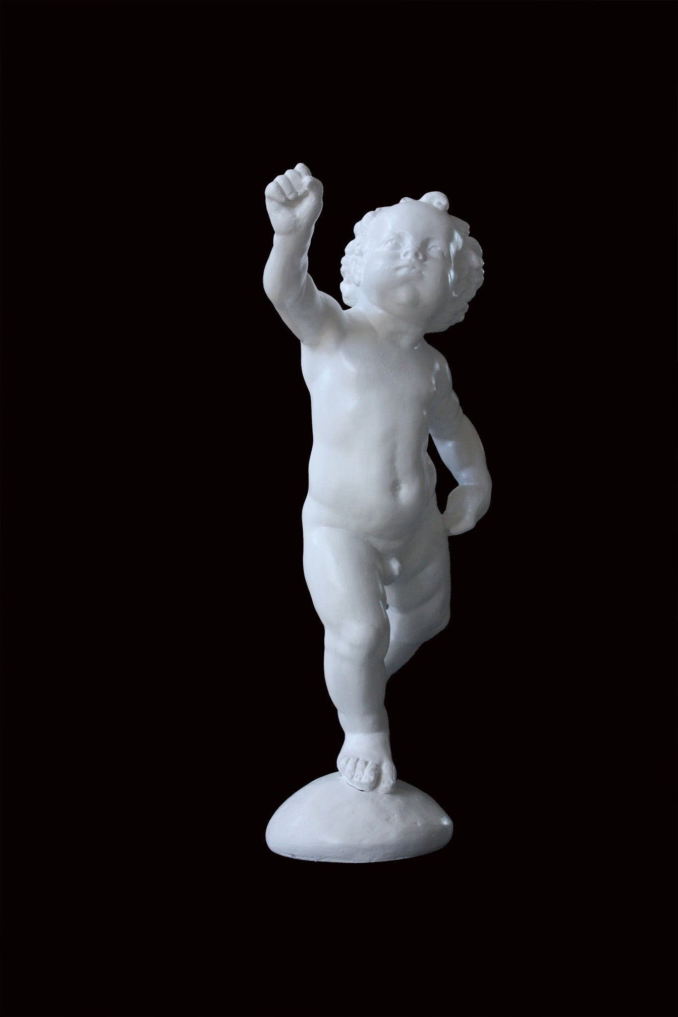 Photo of a sculpture of a cherub on a black background