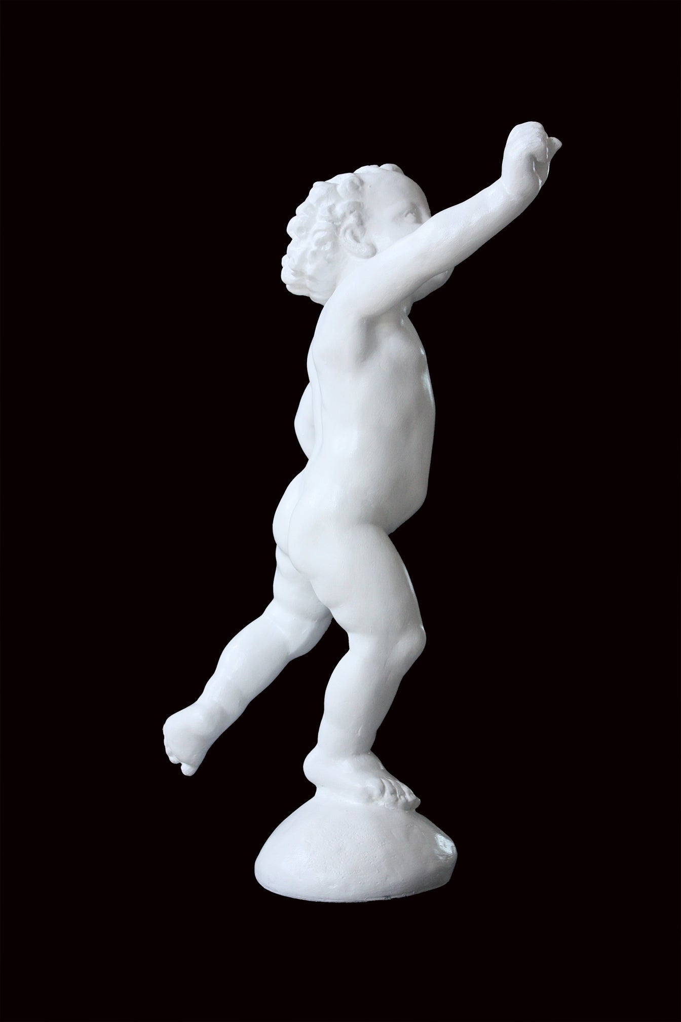 Photo of a sculpture of a cherub on a black background