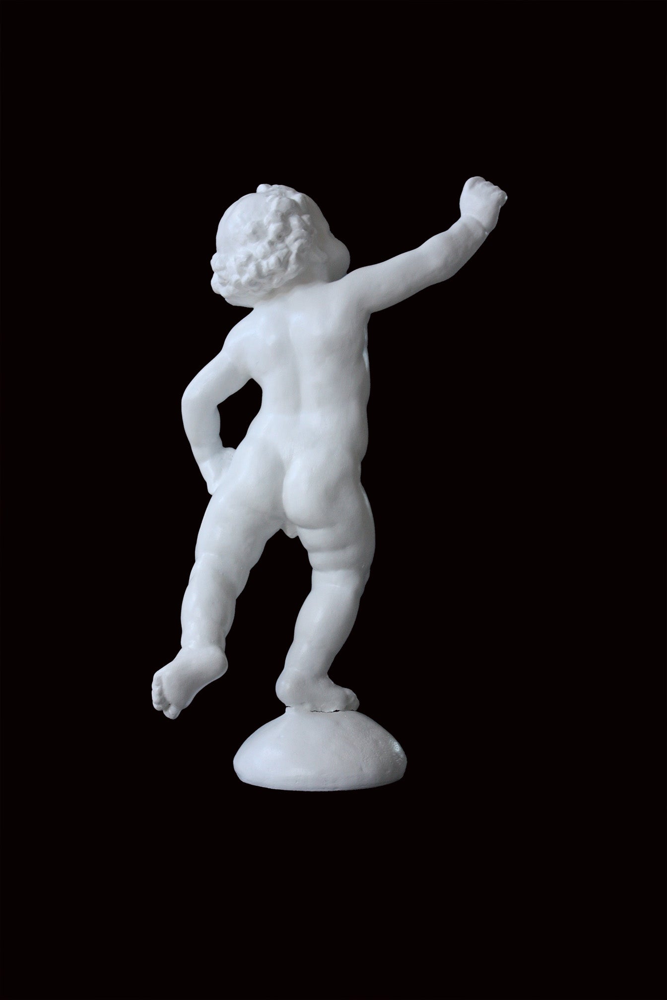 Photo of a sculpture of a cherub on a black background