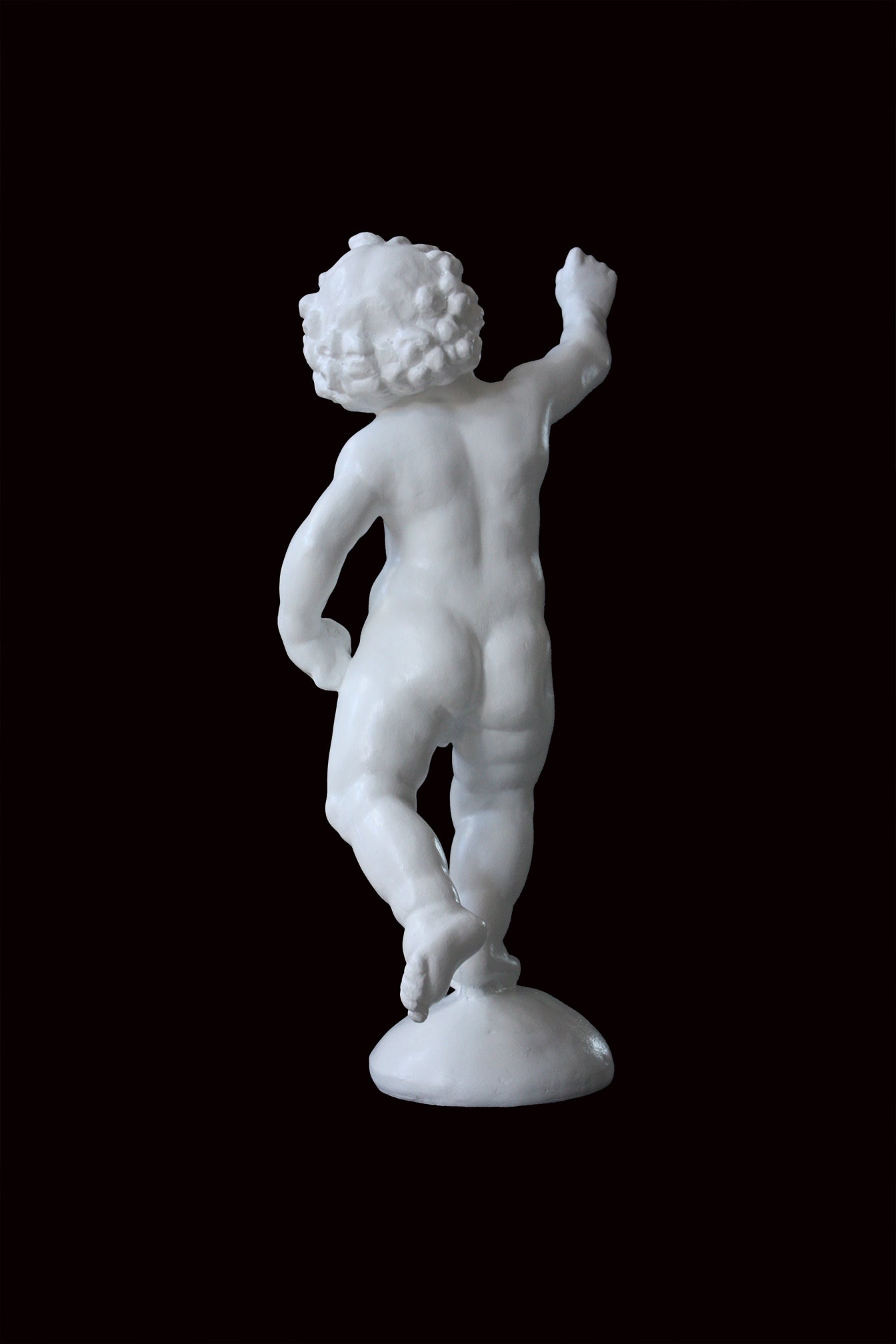 Photo of a sculpture of a cherub on a black background