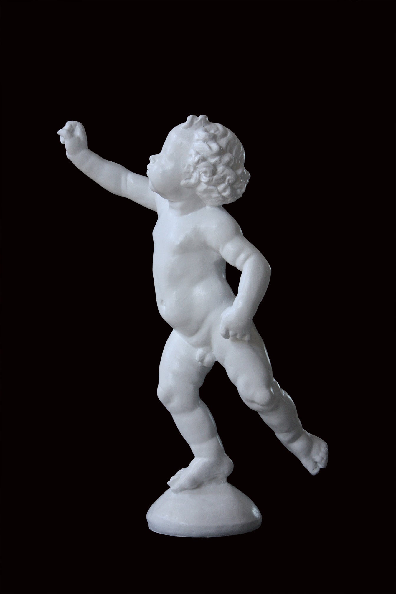 Photo of a sculpture of a cherub on a black background