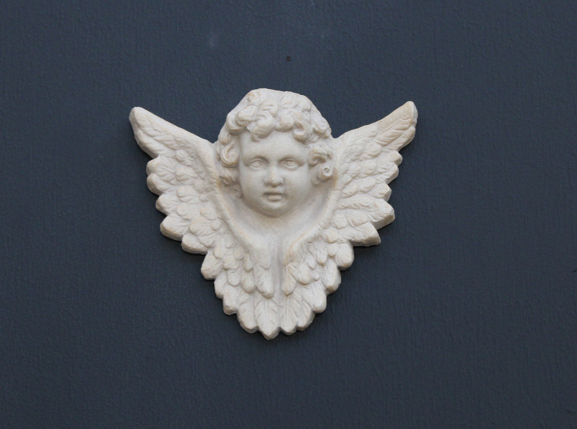 Photo of a  sculpture of a angel on a gray background