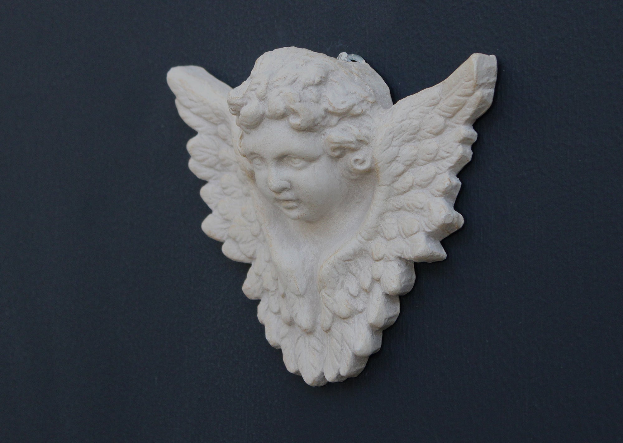 Photo of a  sculpture of a angel on a gray background