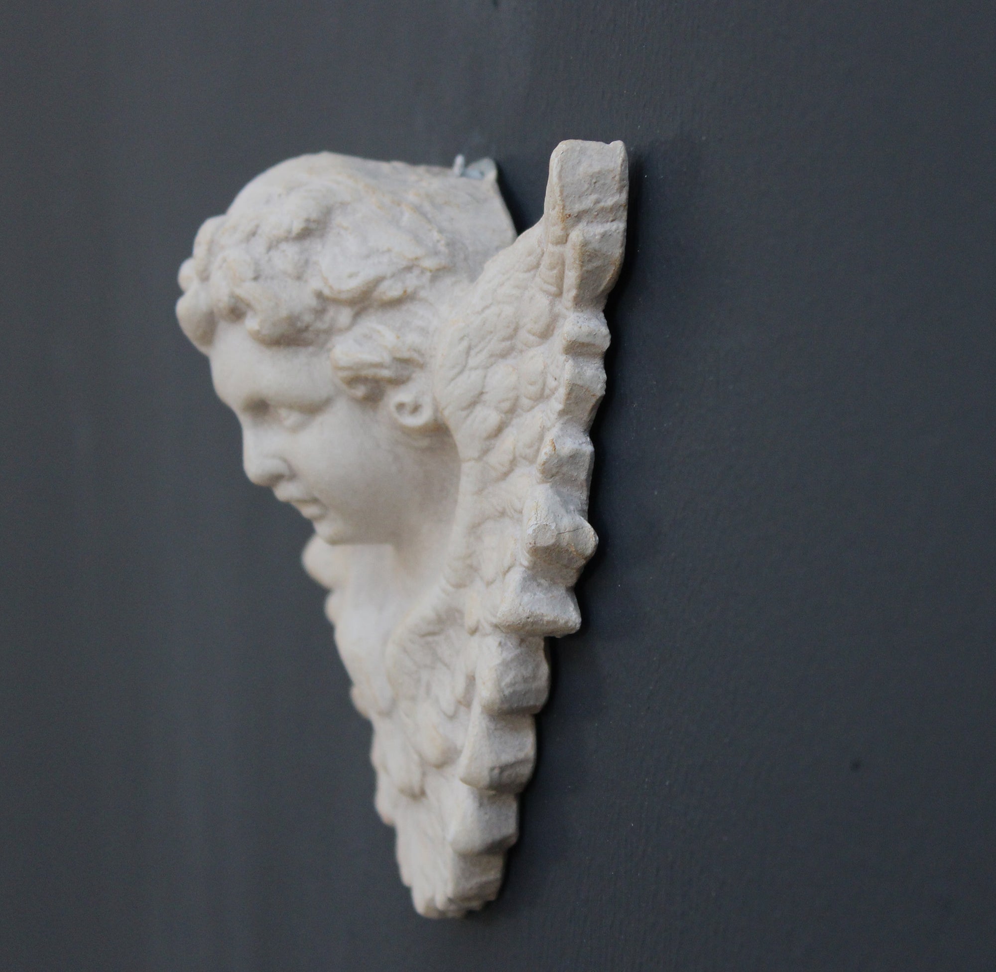 Photo of a  sculpture of a angel on a gray background