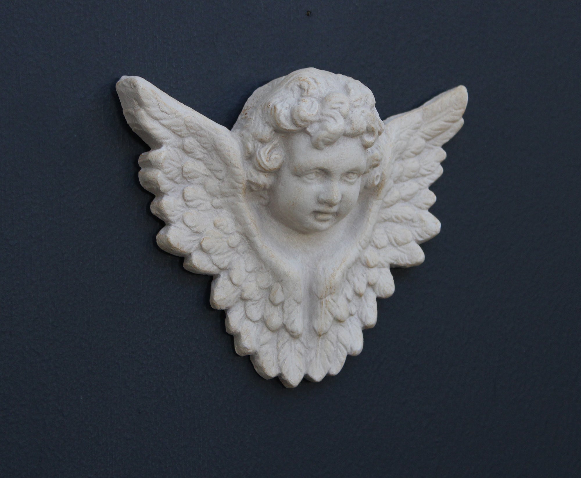 Photo of a  sculpture of a angel on a gray background
