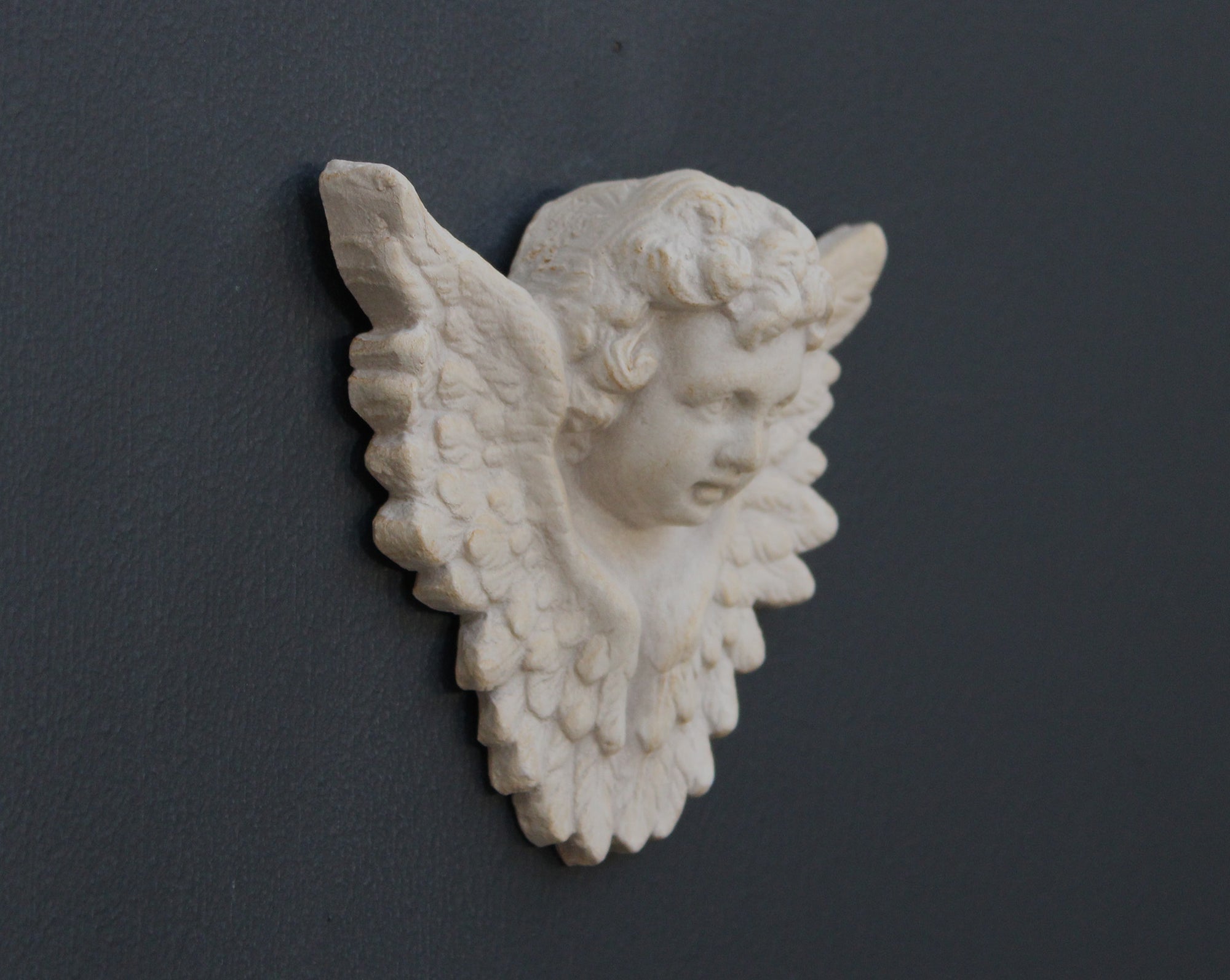 Photo of a  sculpture of a angel on a gray background