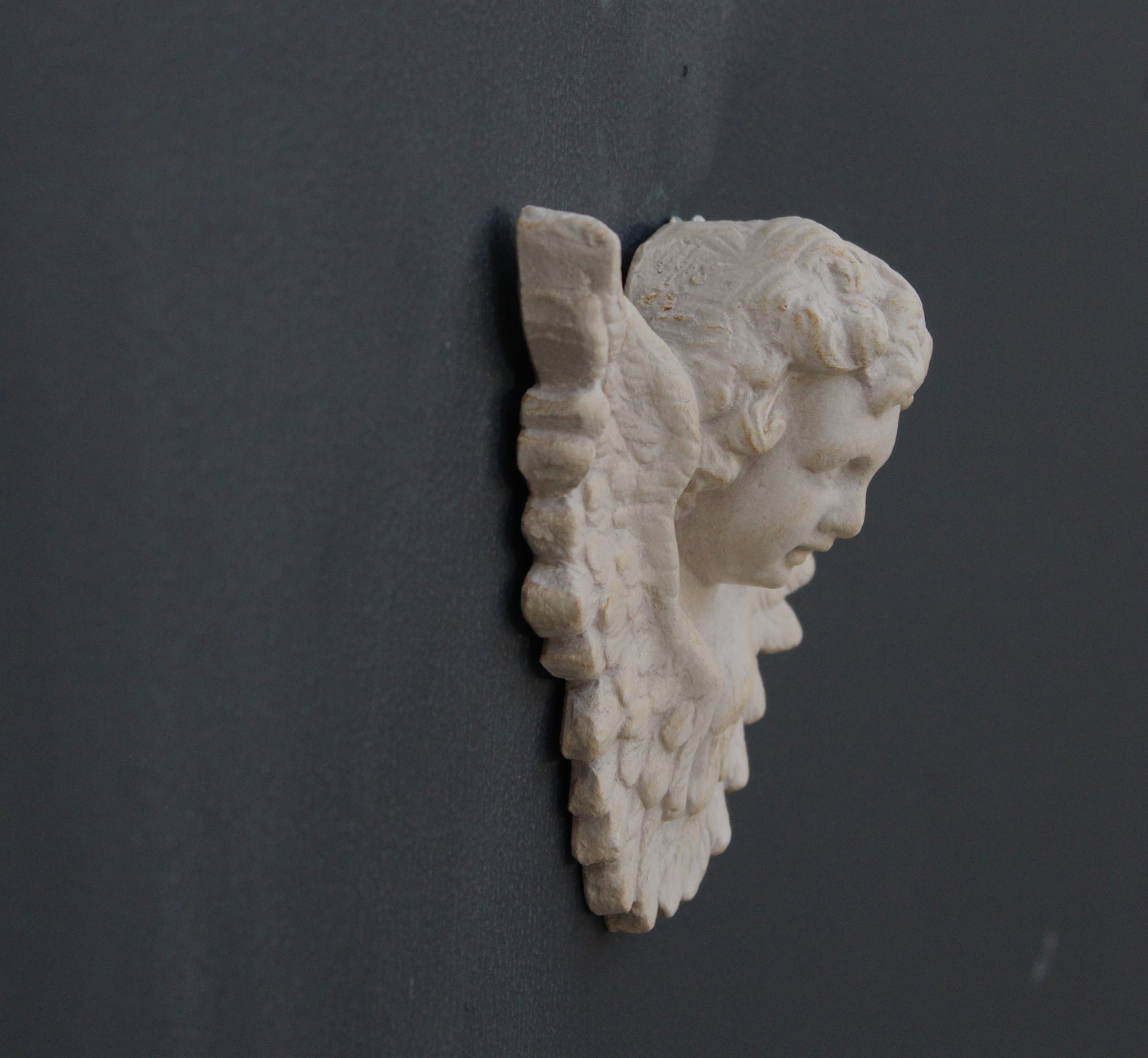 Photo of a  sculpture of a angel on a gray background