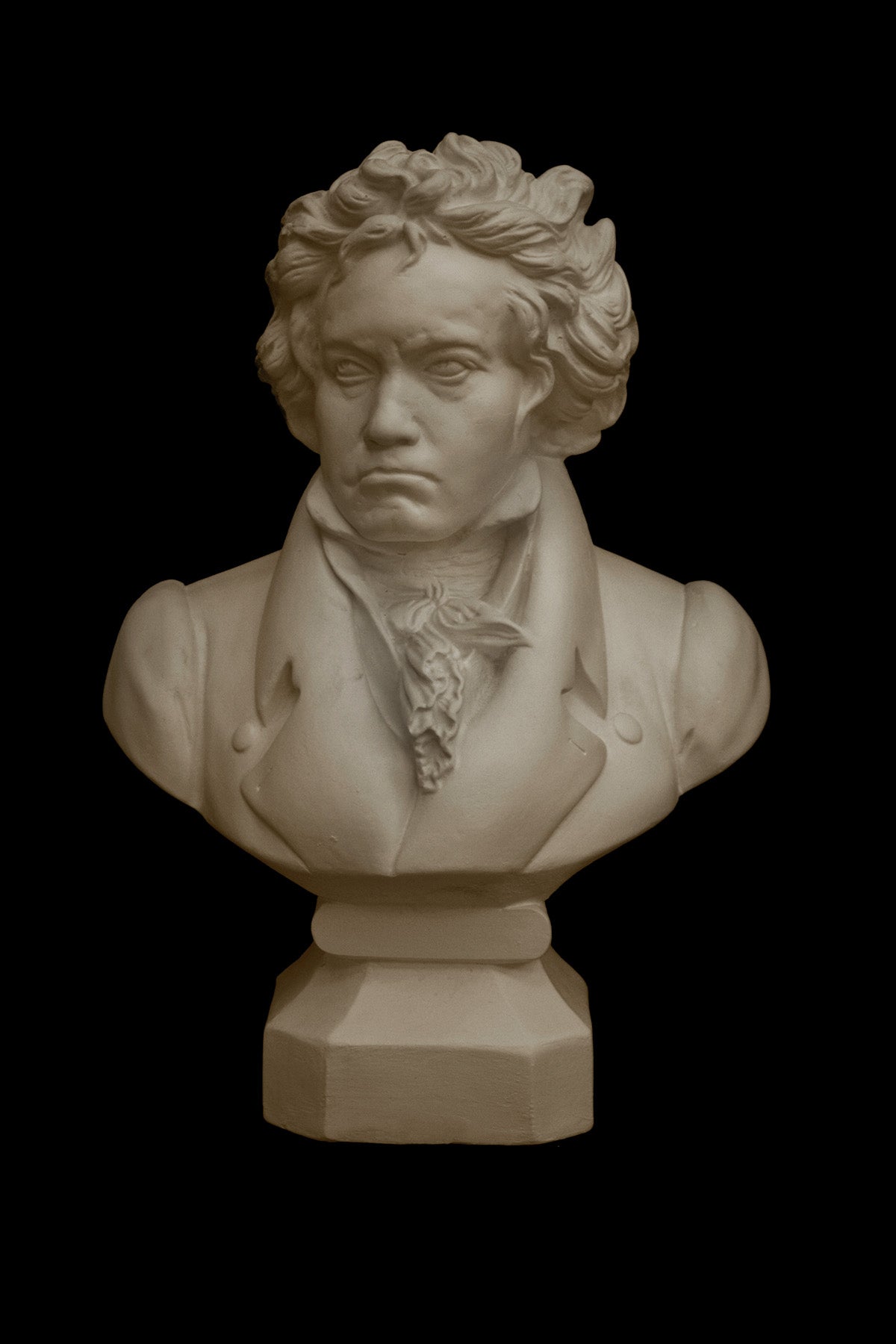 image of a plaster statue of a bust of Beethoven on a black background