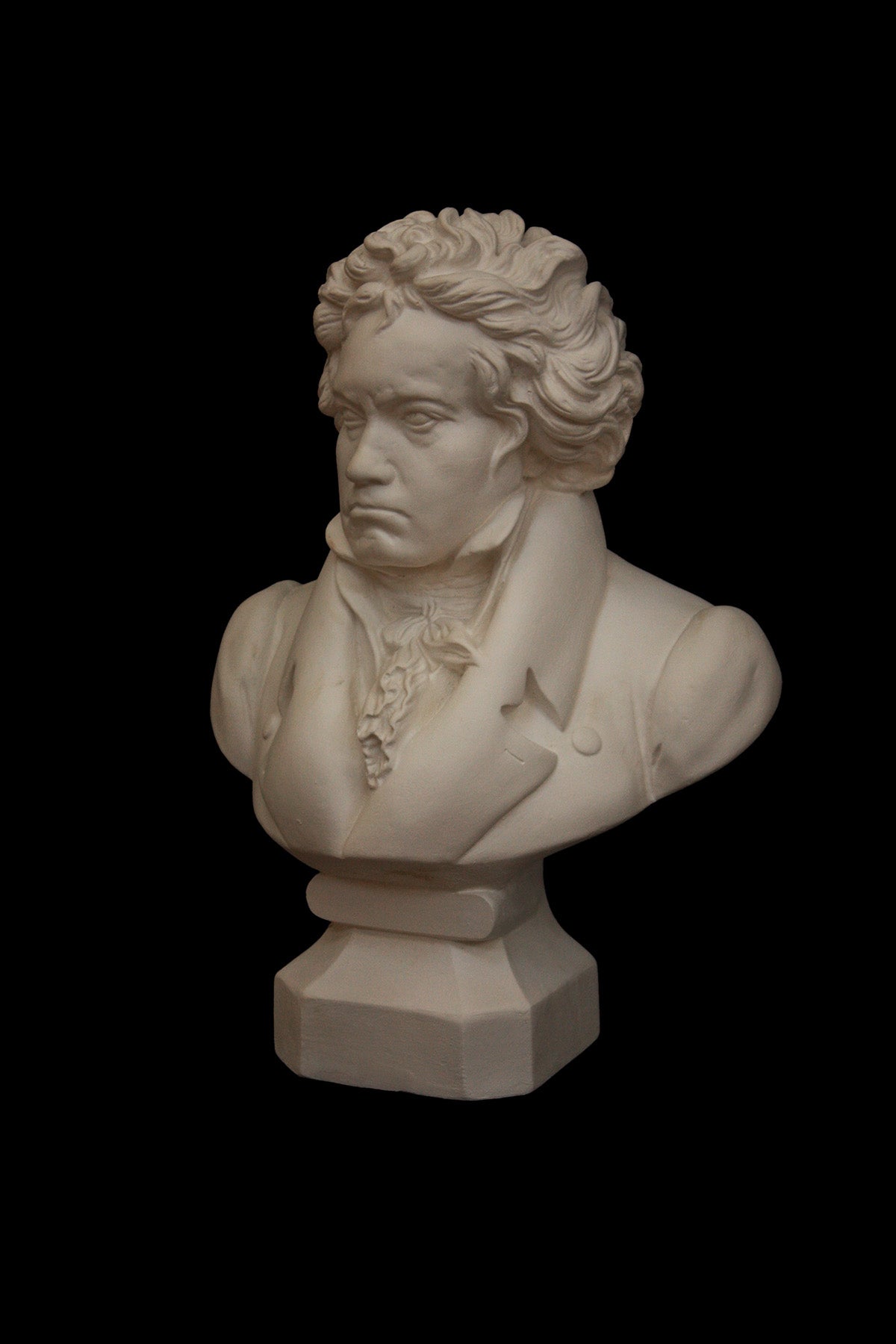 image of a plaster statue of a bust of Beethoven on a black background