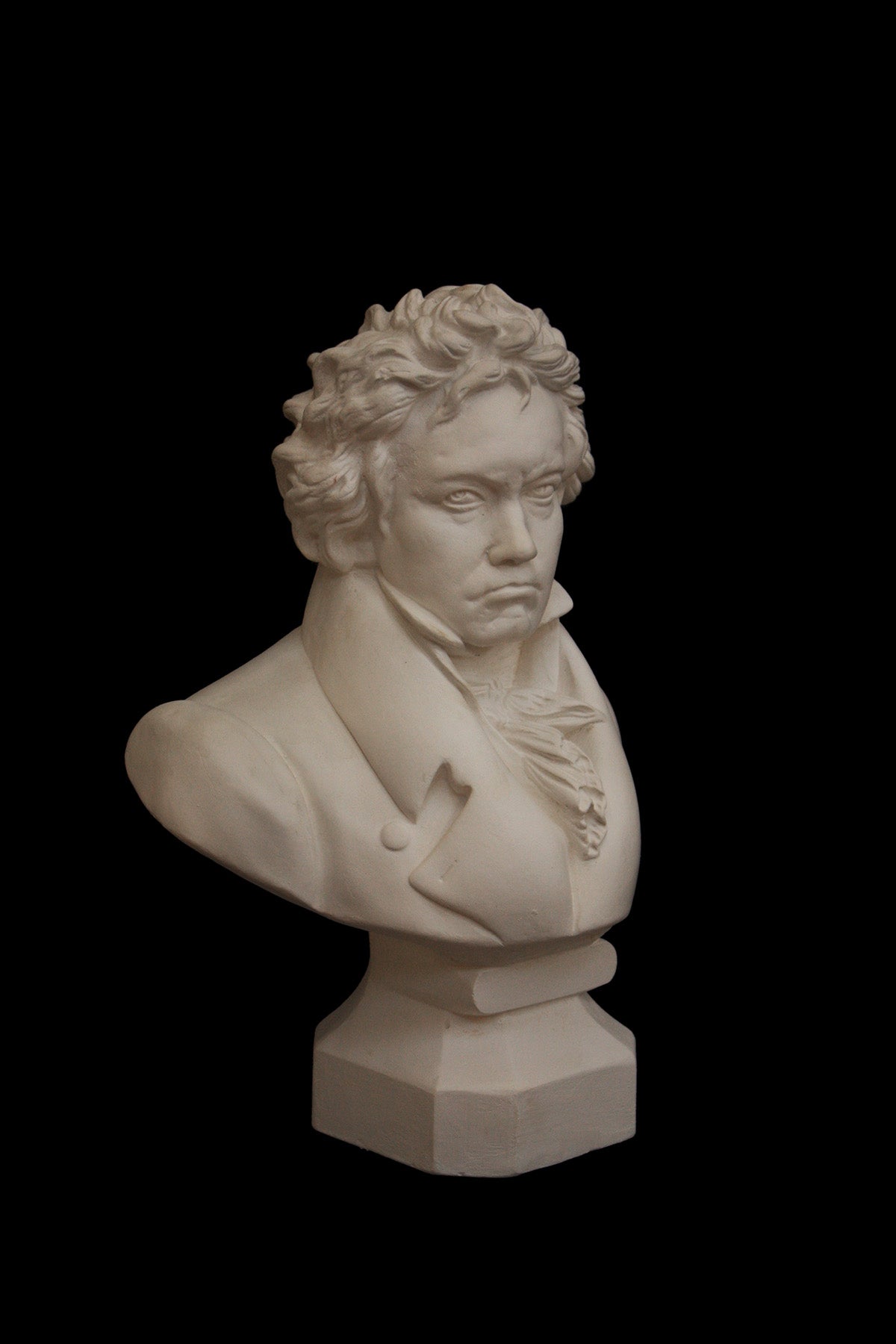 image of a plaster statue of a bust of Beethoven on a black background