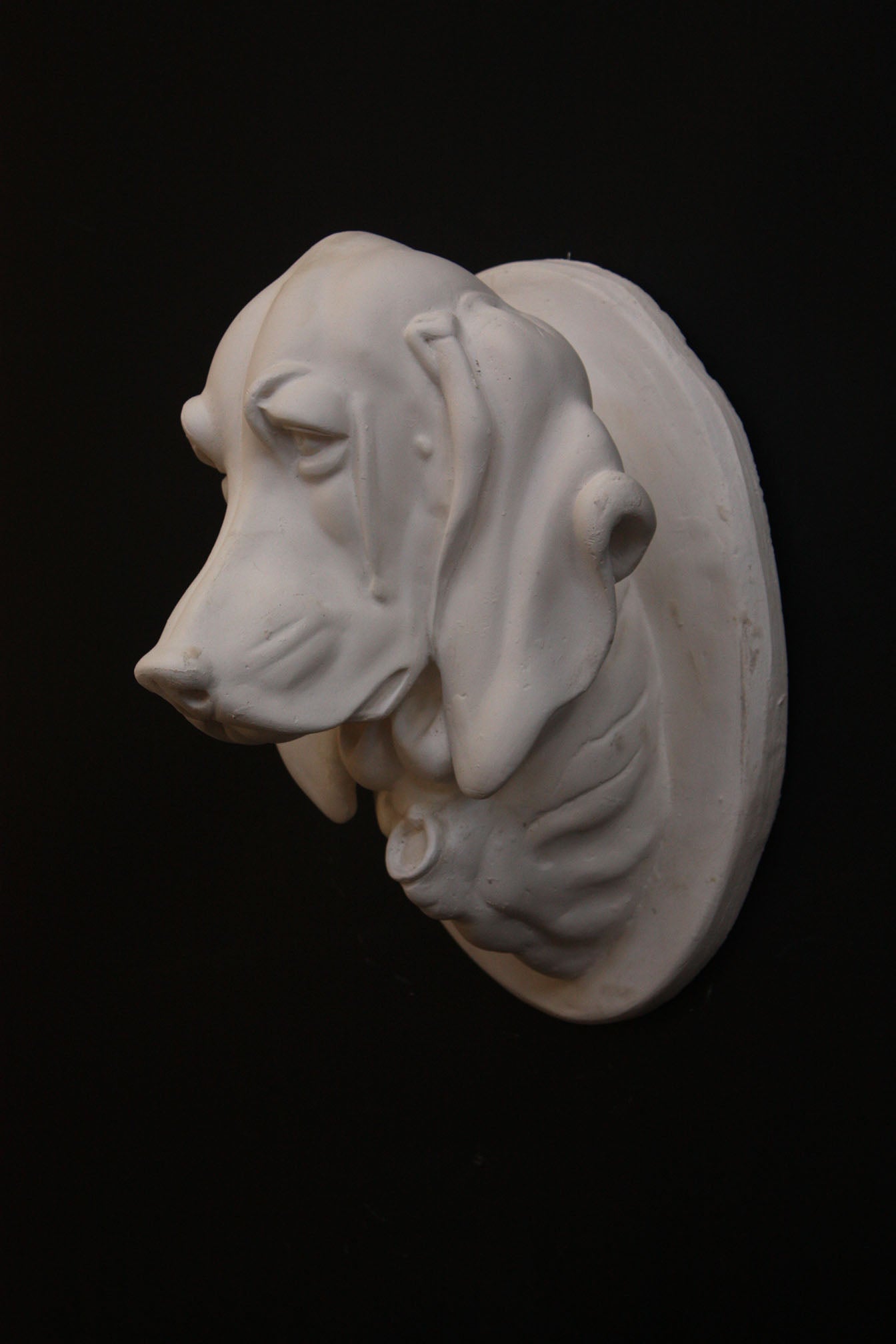 photo of a sculpture of a dog head on a black background 