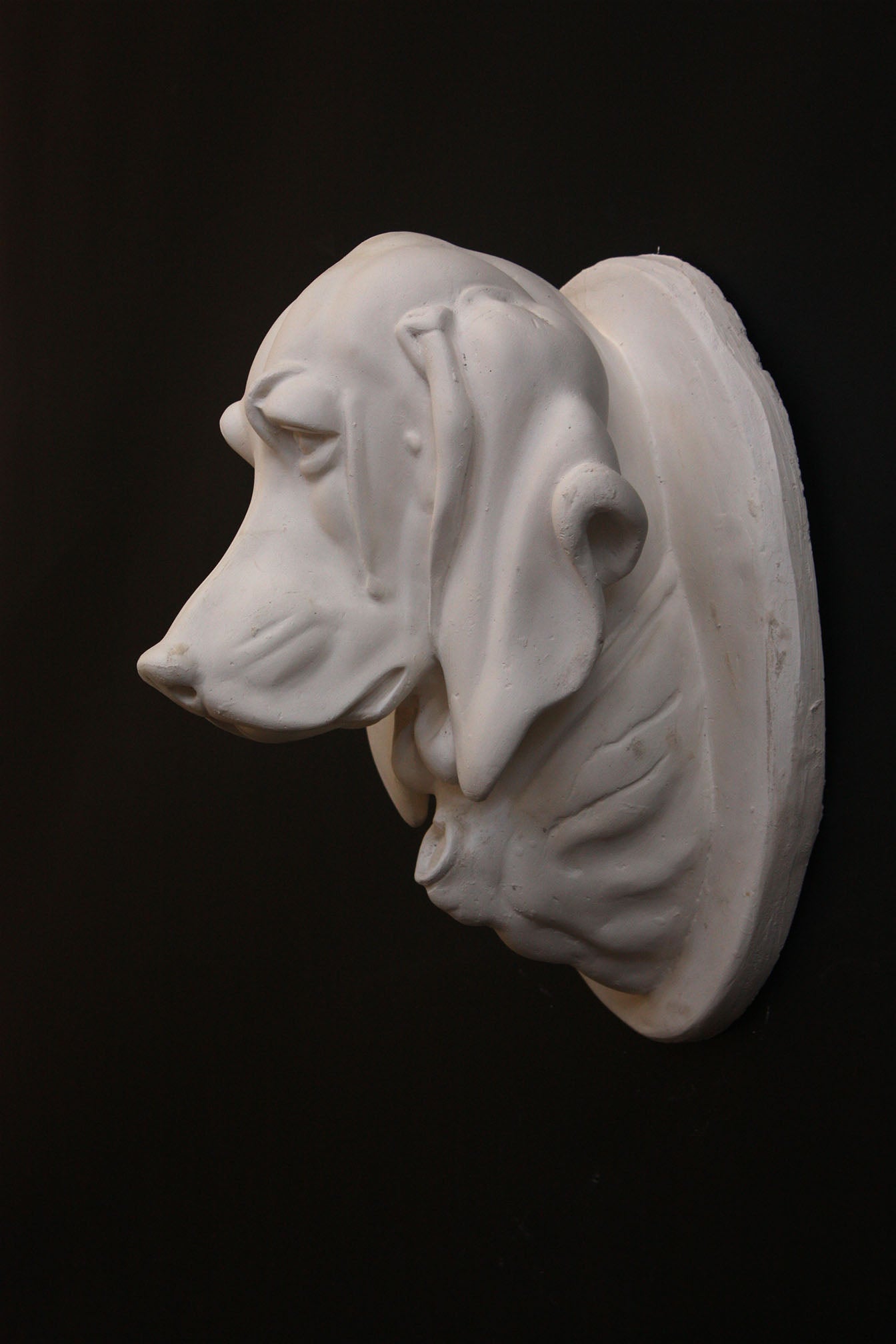 photo of a sculpture of a dog head on a black background 