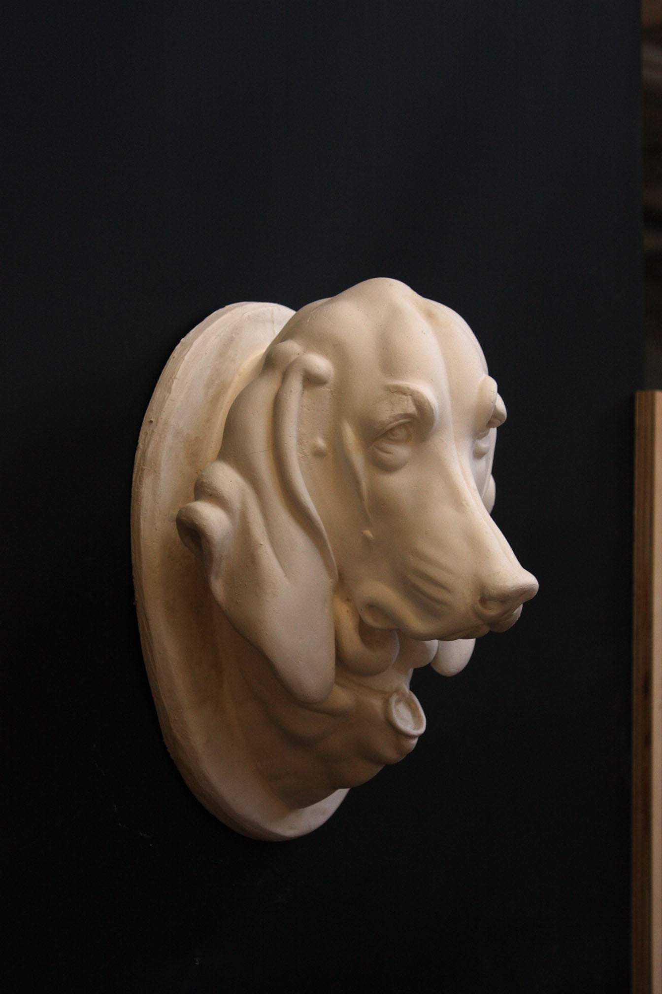 photo of a sculpture of a dog head on a black background 