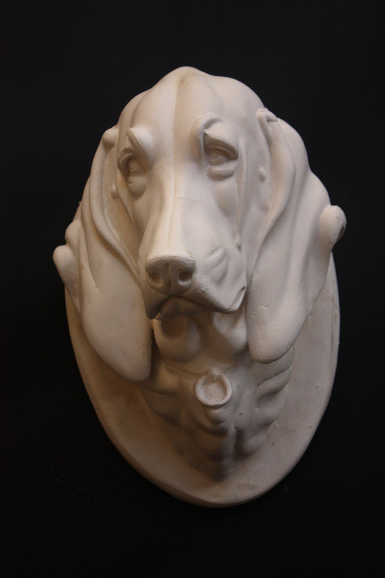 photo of a sculpture of a dog head on a black background 
